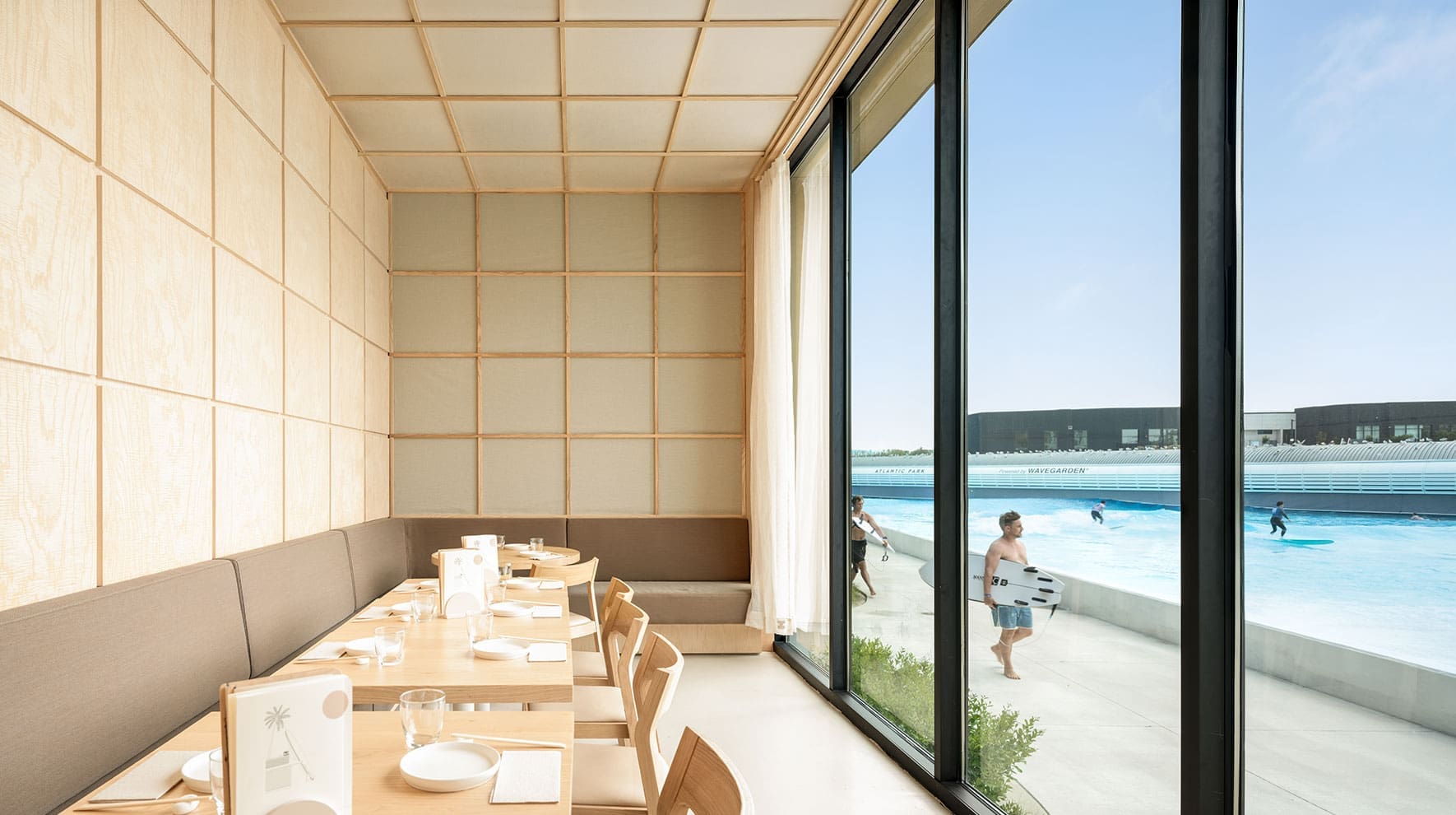 Nami Nori restaurant interior with Japandi design, framed views of Atlantic Park and surf lagoon.